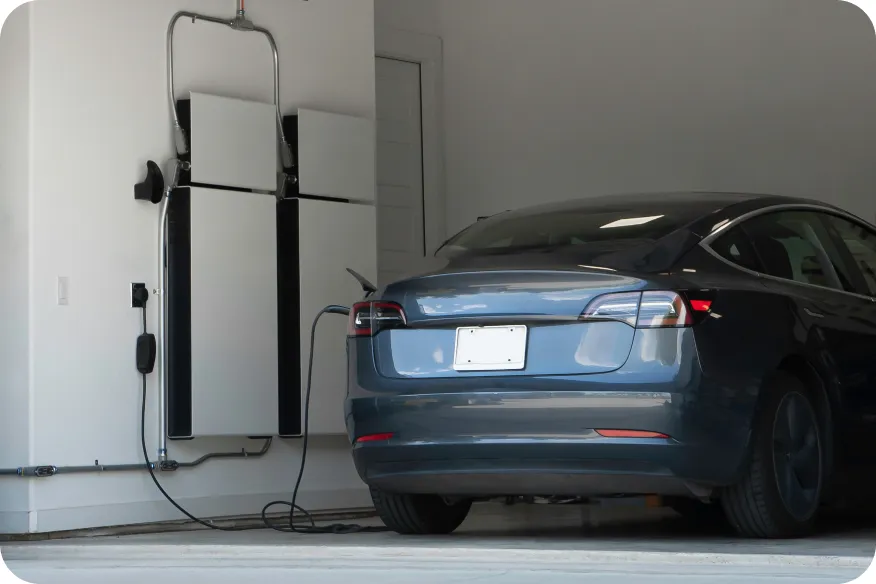 Electric car charging in a garage next to a home battery