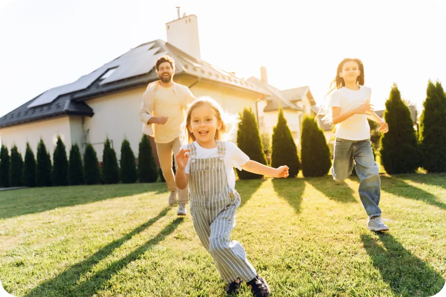 Children running on a lawn outside a home with solar panels