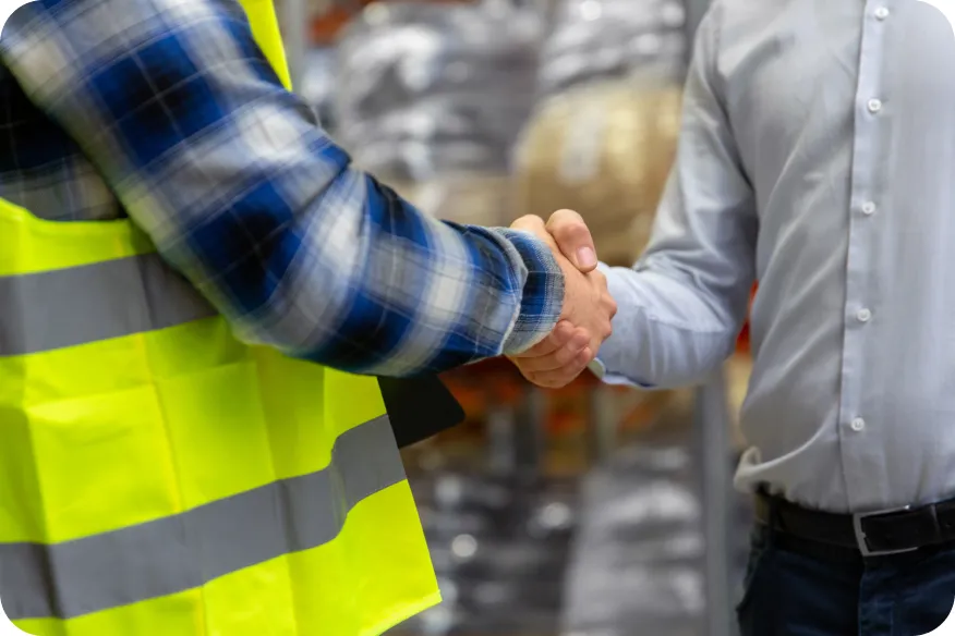 Installer in a safety vest shaking hands with a homeowner