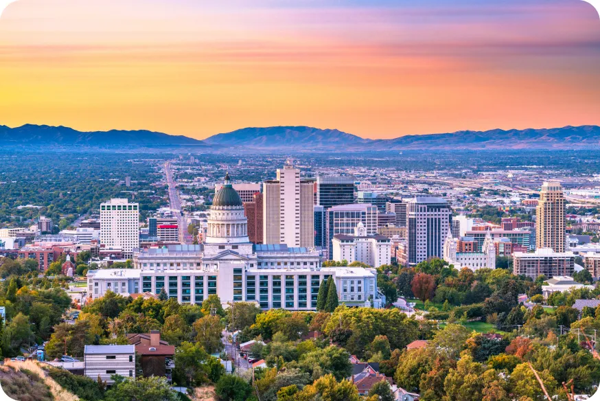 City skyline at sunset with mountains in the background